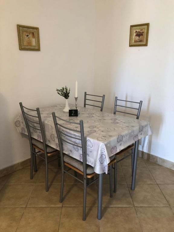 Detalj blagovaonskog stola sa svijećom i maslinovom grančicom