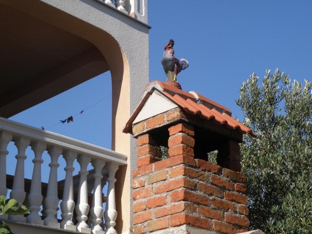 Dimnjak od cigle s figuricom pijetla